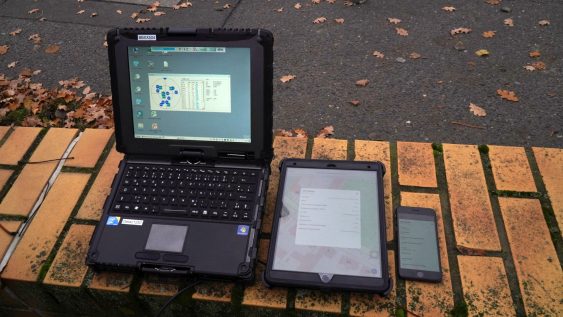 A computer and a phone on a brick surfaceDescription automatically generated